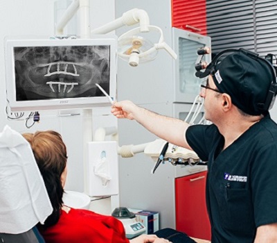 Имплантолог демонстрирует протезирование зубов на 4 имплантах на снимке